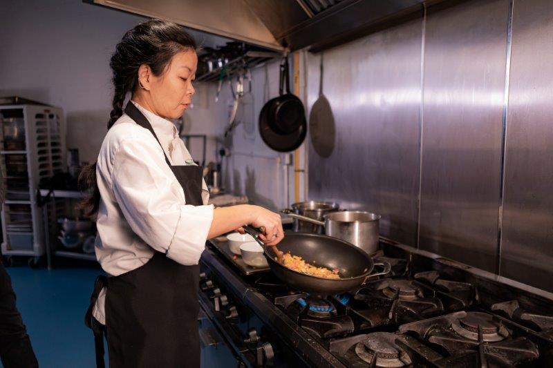 A chef frying food in a wok