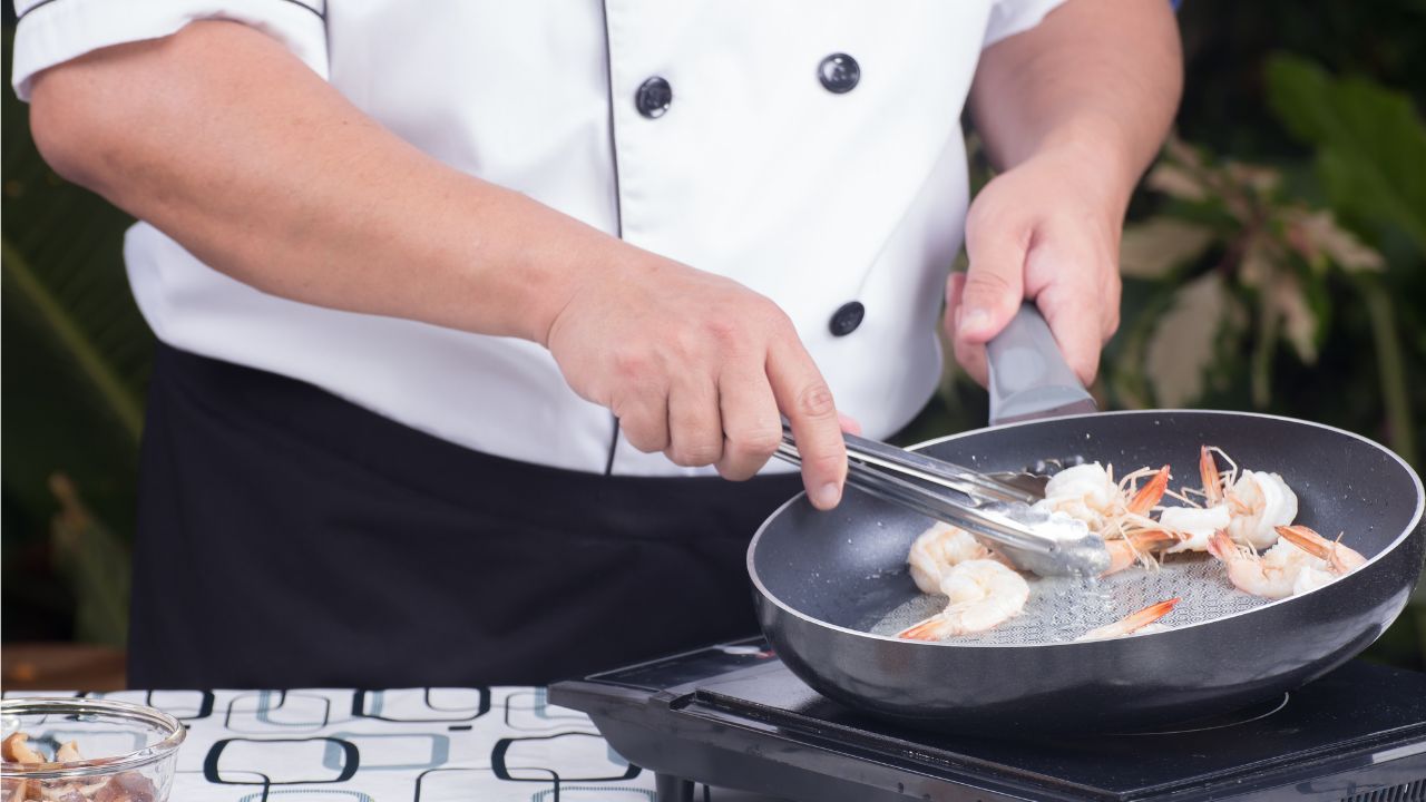 A chef frying food in a wok
